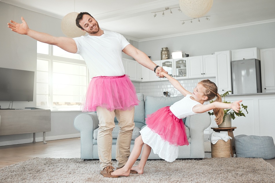 Vater tanzt mit seiner Tochter: Kinder lieben Bewegungsspiele, wenn Eltern dabei mitmachen, umso schöner!
