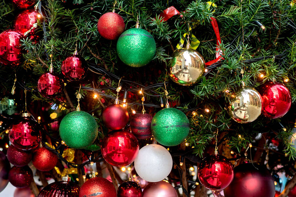 Ein Nadelbaum ist mit zahlreichen Christbaumkugeln und Lichterketten weihnachtlich geschmückt. Weihnachtsfeiern gehören in Unternehmen traditionell zur Adventszeit, doch in der Corona-Krise ist bei größeren Menschenansammlungen Vorsicht geboten.