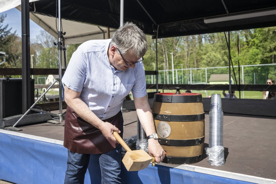 Einsiedels Ortsvorsteher Falk Ulbrich (56, CDU) beim Anstechen des Bierfasses.