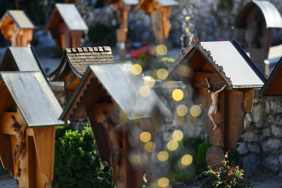Verschiedene Holz- und Metallkreuze sind auf einem Friedhof zu sehen. Allerheiligen ist ein katholisch christliches Fest, an dem aller Heiligen gedacht wird, an diesem Feiertag besuchen auch Familien die Gräber ihrer Verstorbenen.