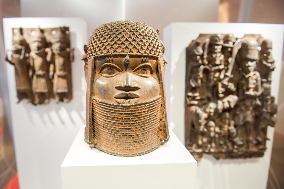 Drei Raubkunst-Bronzen aus dem Benin sind im Hamburger Museum für Kunst und Gewerbe in einer Vitrine ausgestellt. Die Stadt will die ersten Bronzen an die Republik Nigeria zurückgeben. (Archivfoto)