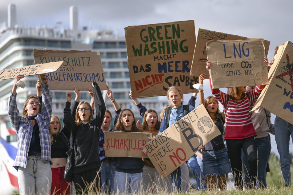 Zahlreiche junge Menschen demonstrieren an der Meyer Werft, wo das Kreuzfahrtschiff "Arvia" aus dem Dock bugsiert wird, gegen den "Luxus auf dem Meer".