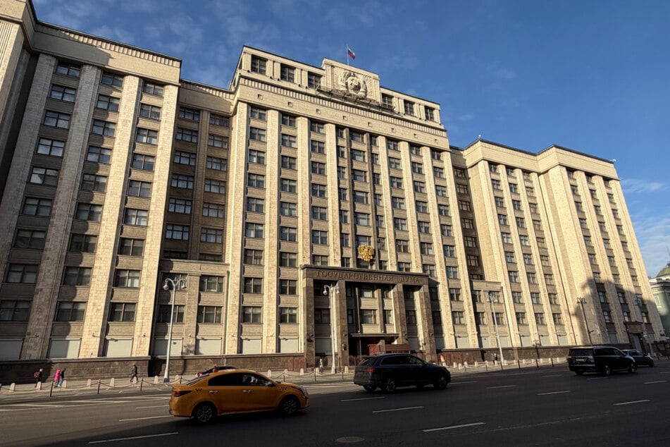 Autos fahren vor der Staatsduma - dem russischen Parlament - vorbei.