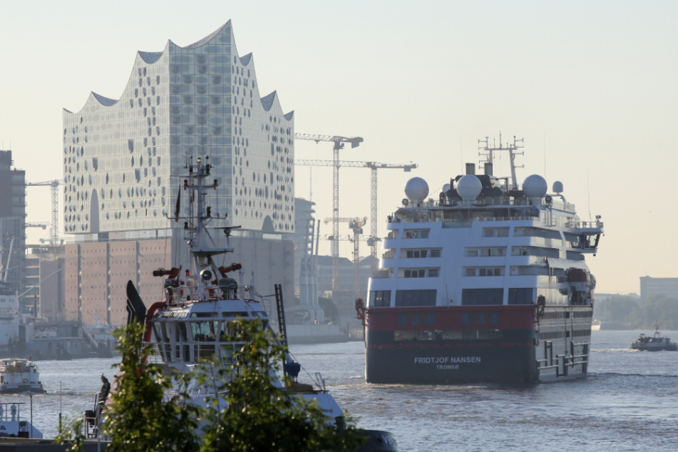 Das Hurtigruten-Schiff "Fridtjof Nansen" läuft am Morgen in den Hafen von Hamburg ein und fährt an der Elbphilharmonie entlang.
