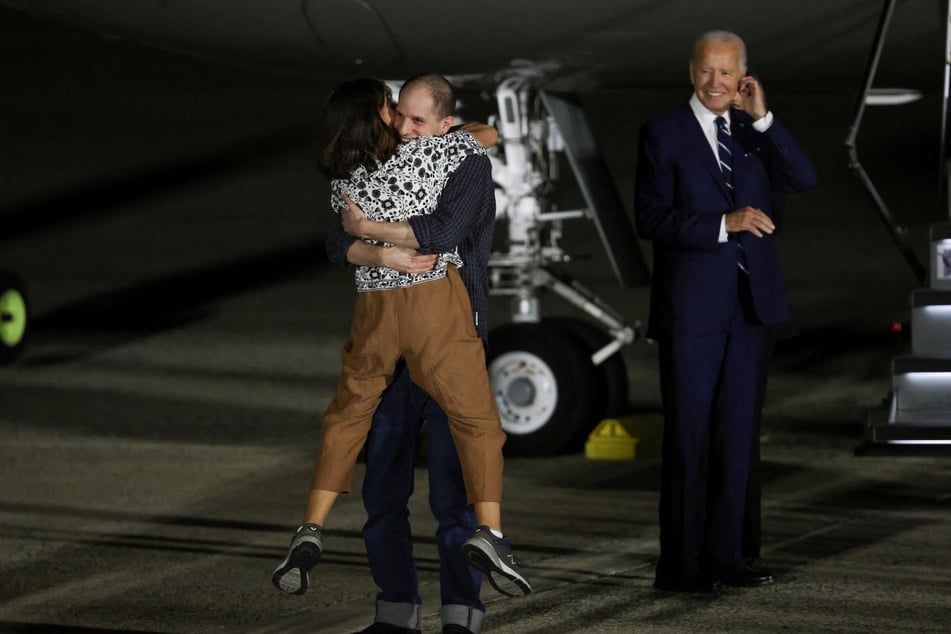 President Joe Biden looks on as Evan Gershkovich is greeted by his mother Ella Milman upon his arrival at Joint Base Andrews in Maryland.