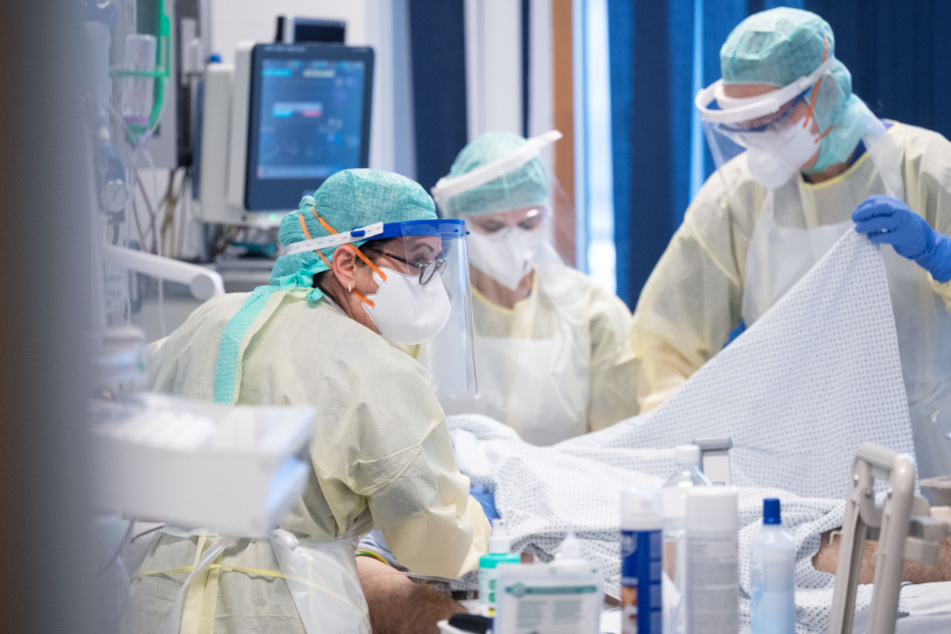 Das Team versorgt einen Covid-19-Patienten, der im künstlichen Koma in einem Patientenzimmer liegt.