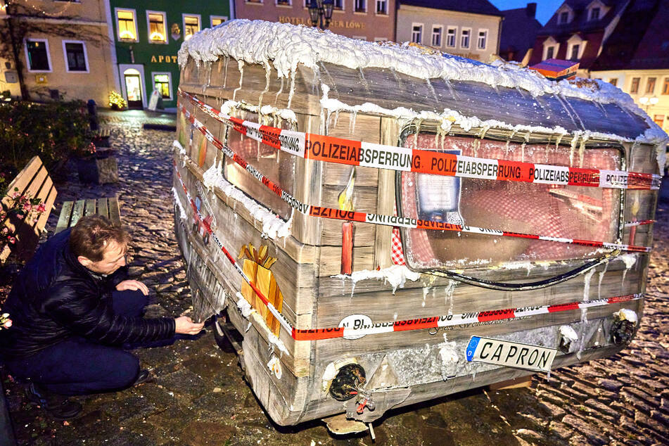 Tatort Marktplatz Stolpen: Die Polizei hat den mit weihnachtlicher Dekoration geschmückten Wohnwagen mit Absperrband umwickelt.
