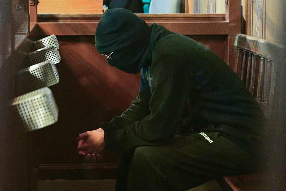 Der Angeklagte hat sich mit Mütze, Sturmhaube und Sonnenbrille komplett verhüllt und hüllt sich auch in Schweigen.