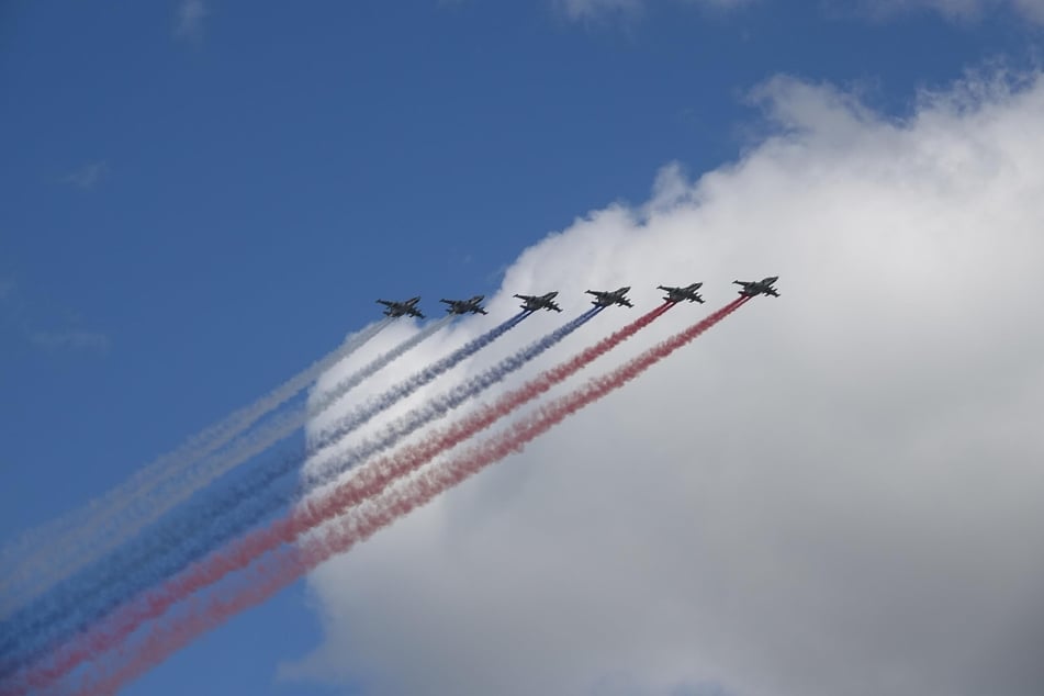 Die russischen Luftstreitkräfte fliegen bei der Militärparade über den Roten Platz und bilden mit farbigem Rauch die russische Staatsflagge.