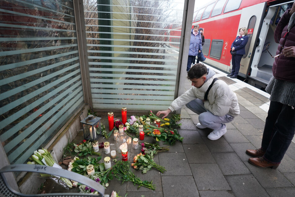 Der 19-jährige Julian, Freund des Getöteten, legt Blumen auf dem Bahnsteig im Bahnhof von Brokstedt ab.