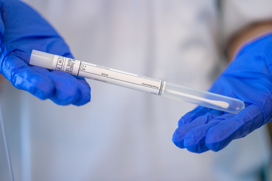 Eine Krankenschwester hält ein Röhrchen mit dem Stäbchen für einen PCR-Test. (Symbolbild)