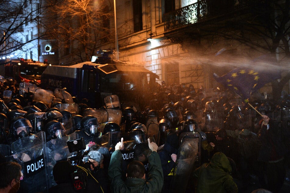 Die Polizei setzt Wasserwerfer vor dem georgischen Parlamentsgebäude in Tiflis gegen die Demonstranten ein.