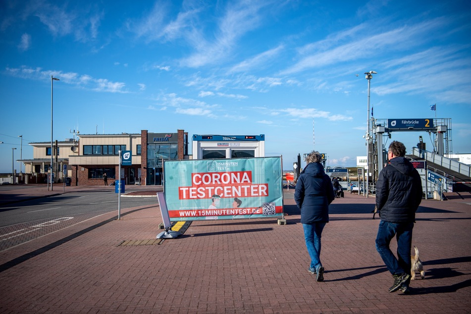 Urlauber gehen am Fähranleger in Norddeich zu einem Zentrum für Corona-Schnelltests.