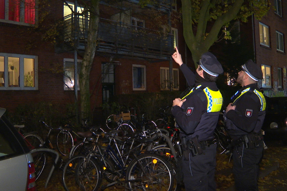 Polizisten stehen vor dem Wohnhaus im Schanzenviertel.