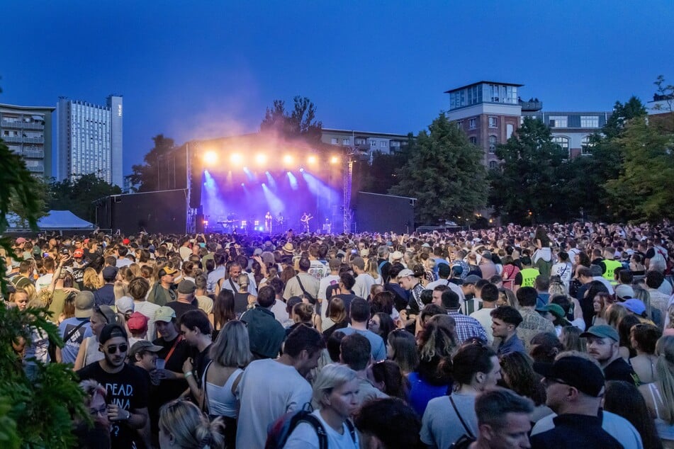 Menschenmassen rings um den Schlossteich, hier beim "Kosmos"-Auftritt der Band Juli. Dem Haubentaucher gefällt's nicht.