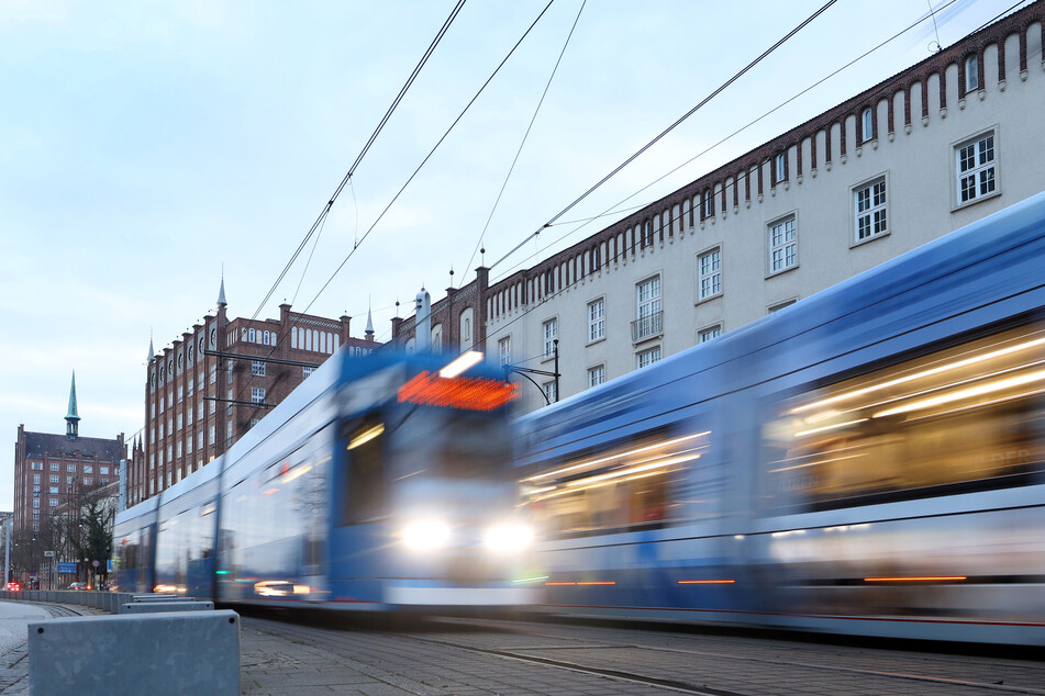 Zwei Straßenbahnen fahren in der Rostocker Innenstadt aneinander vorbei.