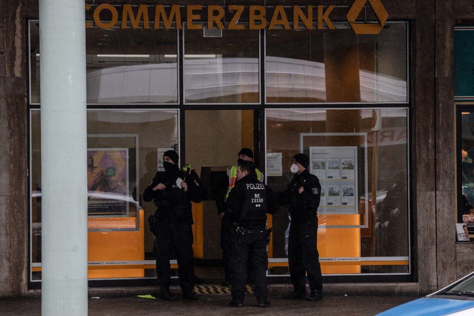 Polizisten stehen nach dem Überfall am Eingang einer Bankfiliale an der Blissestraße in Wilmersdorf.