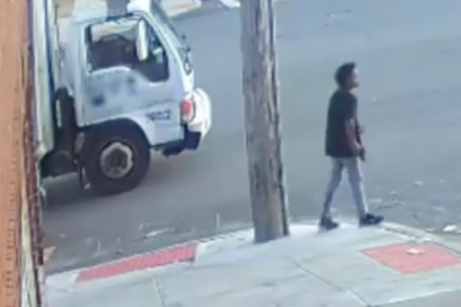 A still from surveillance footage, showing the 13-year-old suspect carrying a gun.