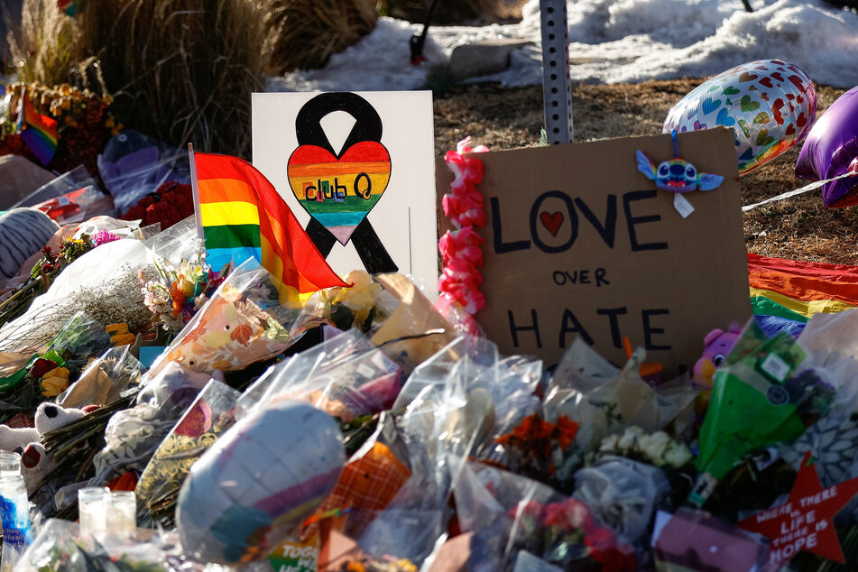 Flowers, signs, and mementos are left at a memorial site for victims after the mass shooting at Club Q.