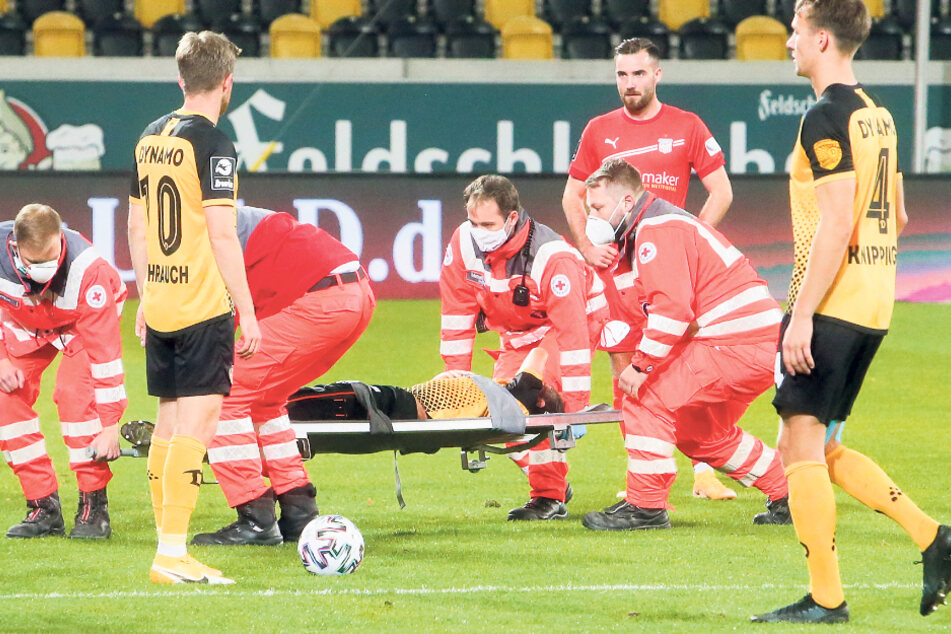 Der verletzte Chris Löwe wird auf einer Trage abtransportiert, Tim Knipping (r.) und sein Teamkollege Patrick Weihrauch sind fassungslos.