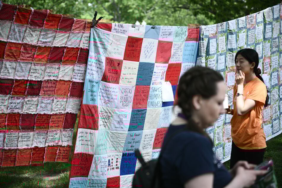 People look at a quilt made by members of Mormon Women for Ethical Government near the US Capitol during a "Quilting for the Constitution: Peace by Piece" event on May 6, 2025.