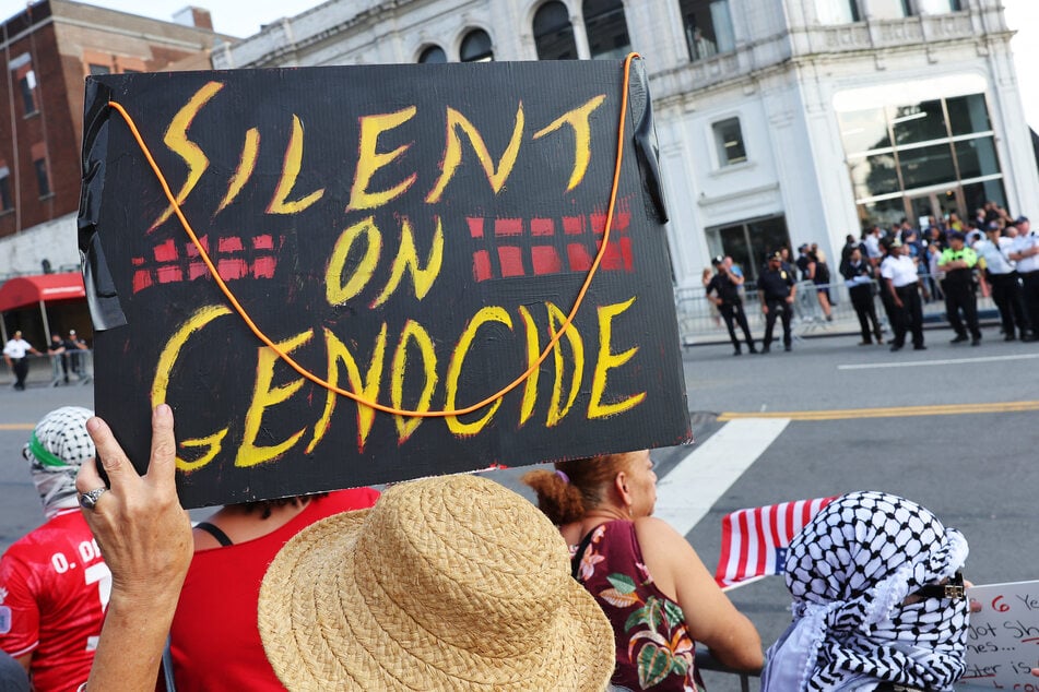 A demonstrator holds a "Silent on Genocide" sign while protesting a campaign event for Democratic presidential candidate Kamala Harris in New York City on August 14, 2024.