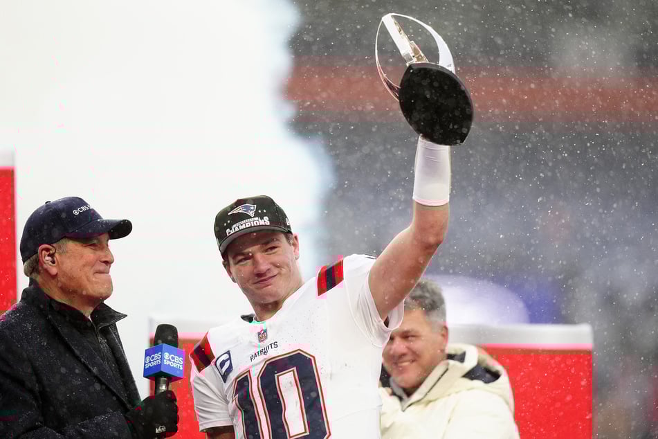 New England Patriots quarterback Drake Maye holds the AFC Championship trophy after defeating the Denver Broncos in the 2026 AFC Championship Game at Empower Field at Mile High.