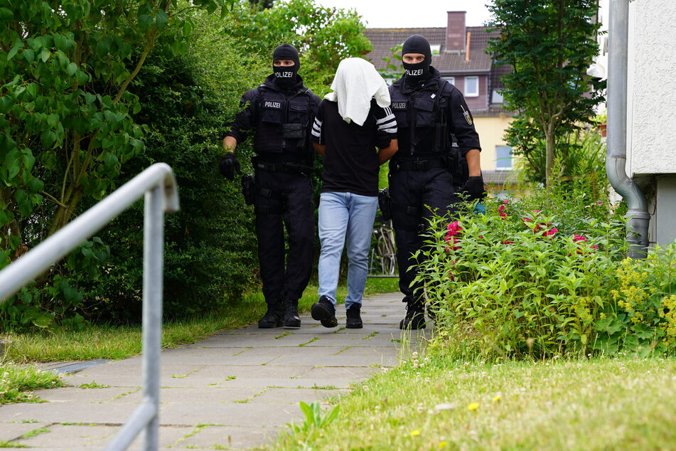 In Osnabrück wurde einer der Festgenommenen von der Polizei abgeführt.