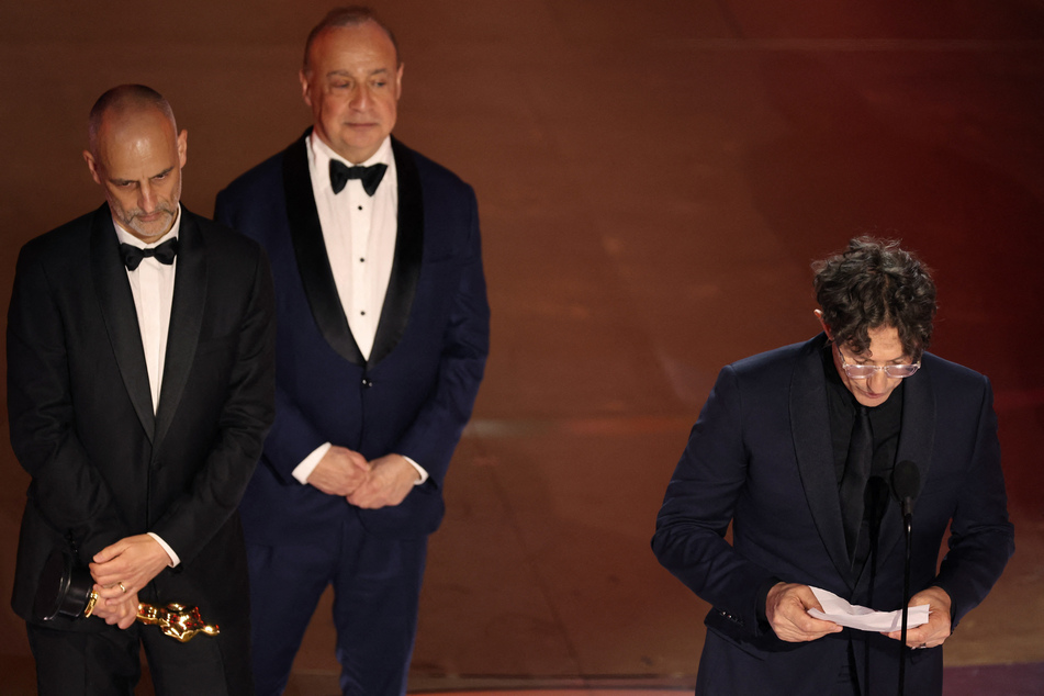 Director Jonathan Glazer (r.) delivers his acceptance speech after winning the Oscar for Best International Feature Film for The Zone of Interest.