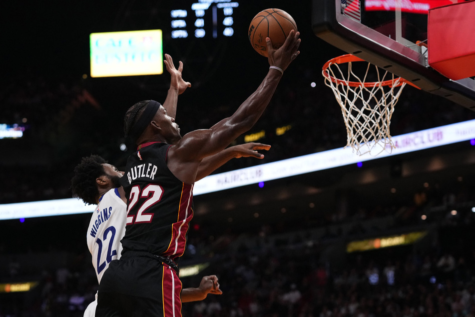 Miami Heat forward Jimmy Butler shoots the ball around Golden State Warriors forward Andrew Wiggins during the second half at FTX Arena.