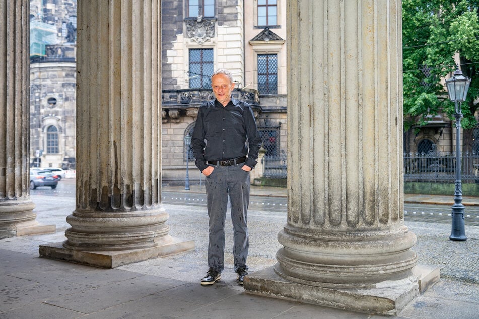 Gilbert Lupfer (73) bei den Säulen der Schinkelwache, im Hintergrund das Residenzschloss, sein ehemaliger Arbeitsplatz.