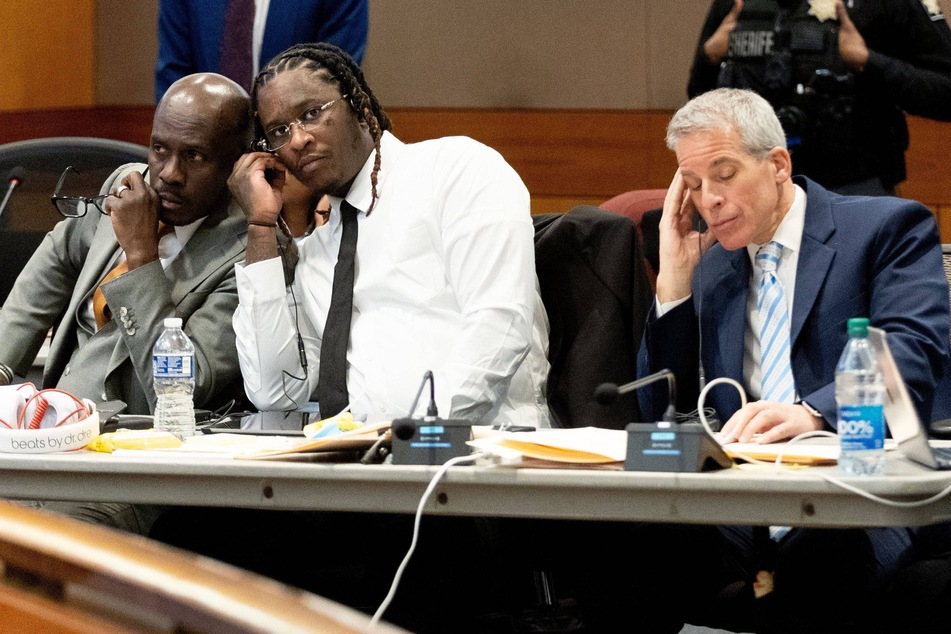 Young Thug listens in on a bench meeting between the judge and another attorney before the opening statements in his Fulton County gang and racketeering trial on November 27, 2023.