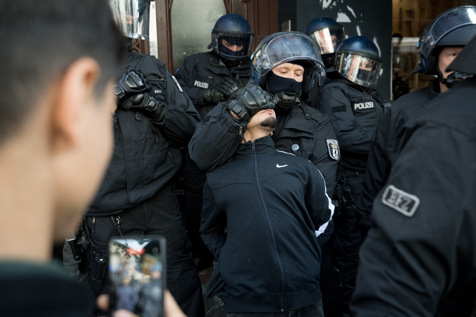 In Berlin-Neukölln wird ein Jugendlicher von der Polizei festgehalten.