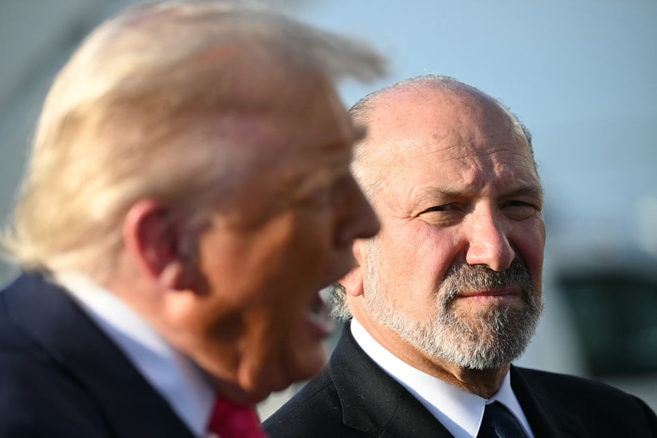 Secretary of Commerce Howard Lutnick (r.) listens as President Donald Trump speaks to reporters at Joint Base Andrews in Maryland on July 15, 2025.