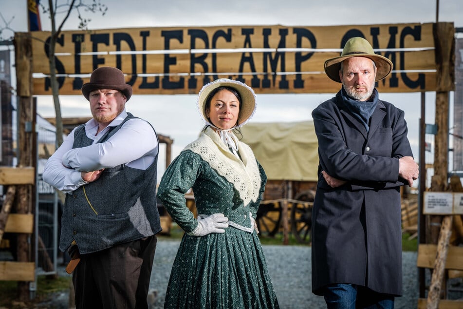 (v.l.n.r) Felix Tillner, Tiffany Rehnert und Wachmann Enrico Damm vor dem Eingang zum Siedlercamp. (Archivbild)