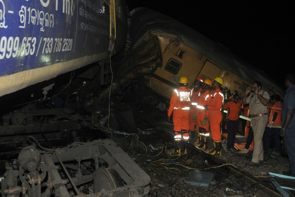 Rettungskräfte am Unfallort, wo ein herannahender Zug mit einem stehenden Zug kollidierte.