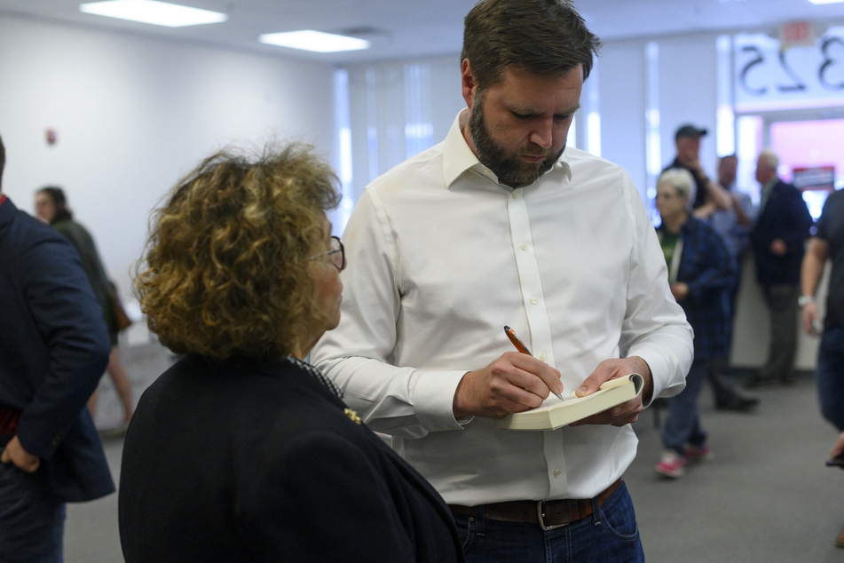 Republican Senate candidate for Ohio JD Vance signs his book Hillbilly Elegy for a supporter at a campaign office on October 13, 2022 in Canton, Ohio.