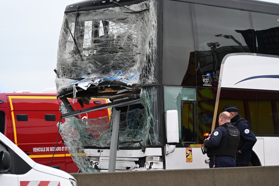 Beamte der französischen Polizei neben einem der verunglückten Busse.