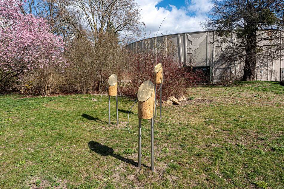 Die drei Figuren fangen mit ihren goldenen Messinggesichtern das Sonnenlicht ein und schützen gleichzeitig die darunterliegenden Nistgänge.