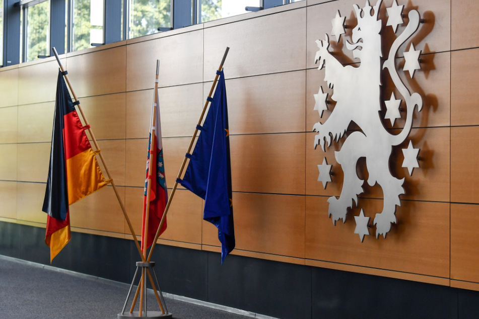 Die Deutschlandfahne, die Fahne der EU und die Fahne von Thüringen, stehen im Thüringer Landtag vor dem Wappen des Landes: Im April soll eigentlich ein neuer Landtag gewählt werden.