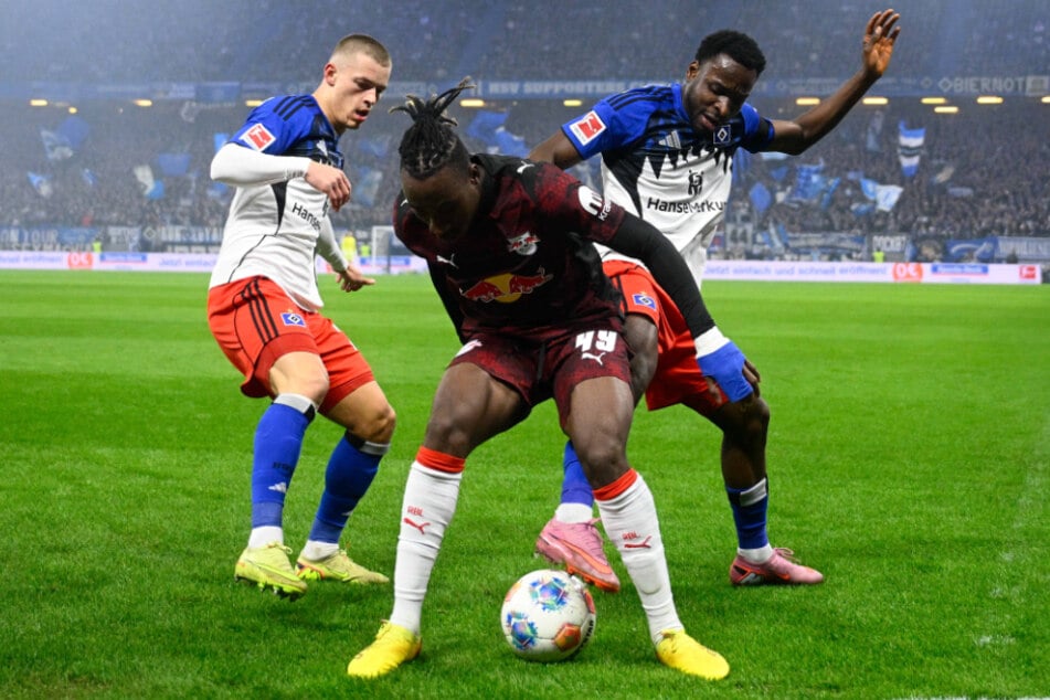 Mit vereinten Kräften versuchen Hamburgs Miro Muheim (l.) und Philip Otele (r.) Leipzigs Yan Diomande vom Ball zu trennen.