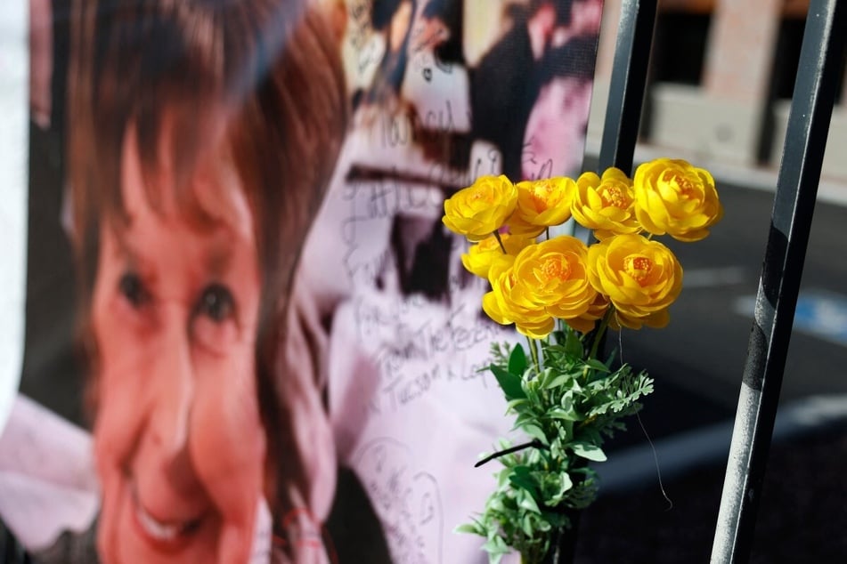 Yellow flowers hang near a photograph of Nancy Guthrie on March 1, 2026 in Tucson, Arizona.