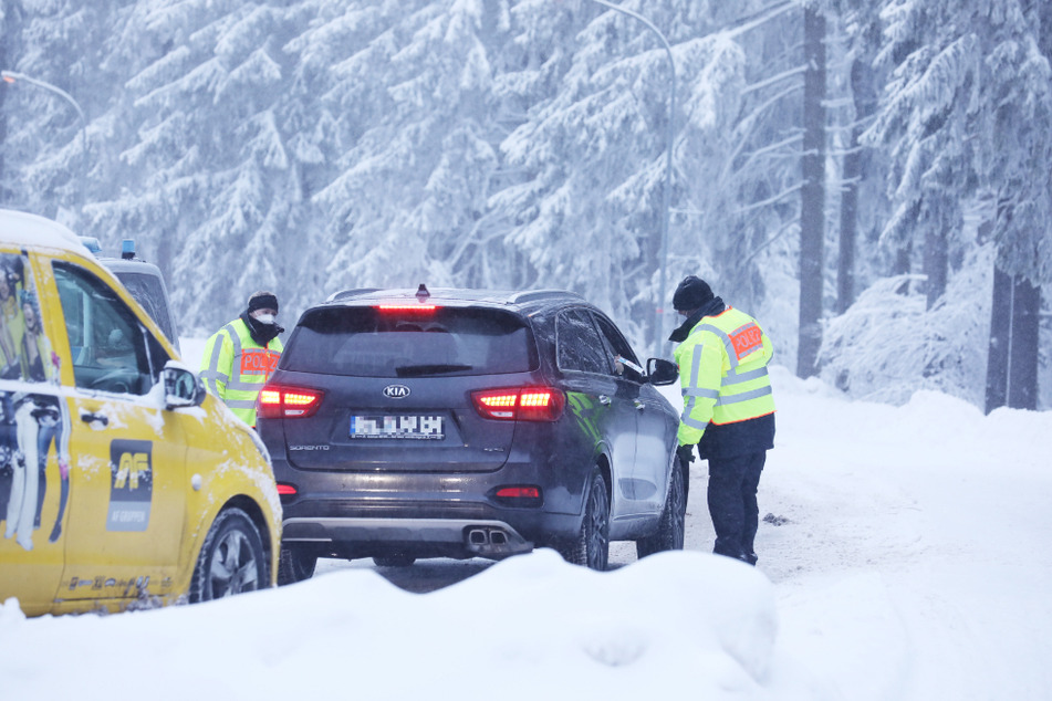 Polizeibeamte stehen an einer Zufahrtsstraße zum Grenzadler und kontrollieren Fahrzeuge. Oberhof riegelt sich vor Tagestouristen ab.