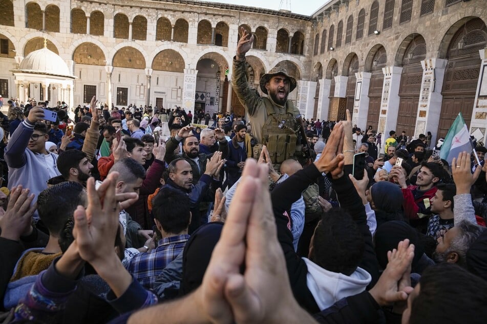 Syrische Kämpfer und Zivilisten skandieren Slogans, während sie sich vor dem Freitagsgebet in der Umayyad-Moschee in Damaskus versammeln.