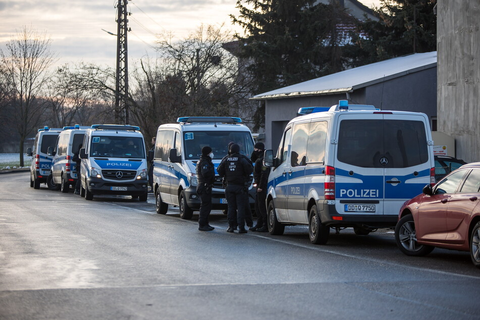 Zahlreiche Mannschaftswagen der Polizei stehen am Quesitzer Rittergut bei Leipzig - hier wurde ein Autohandel durchsucht.