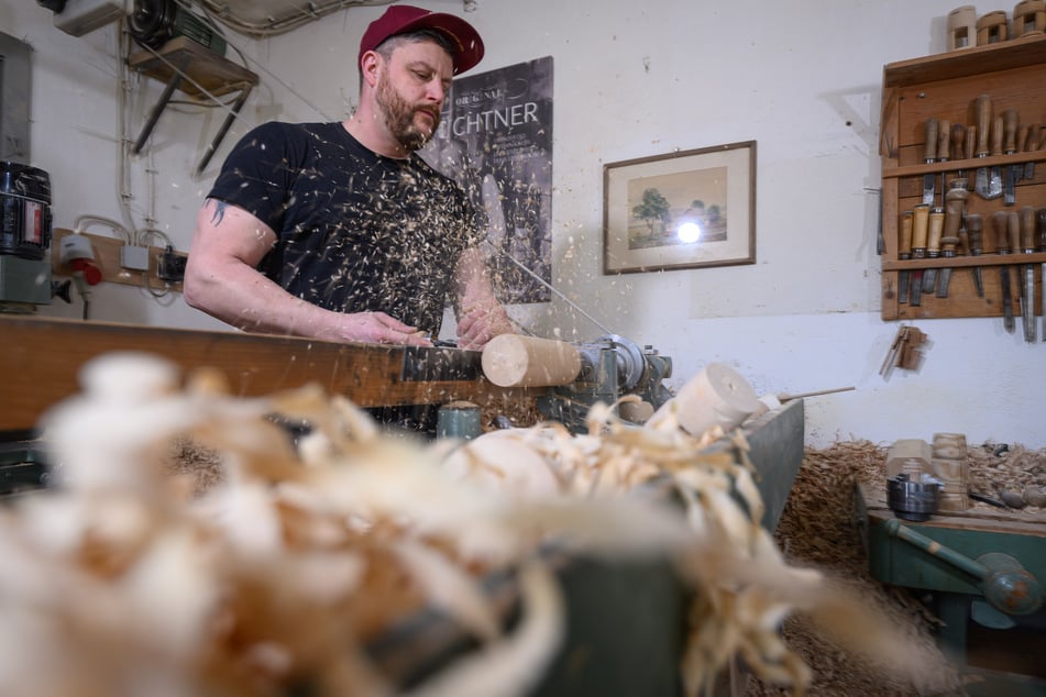 Holzspielzeugmacher Markus Füchtner drechselt in seiner Werkstatt in Seiffen den Körper eines Nussknackers.