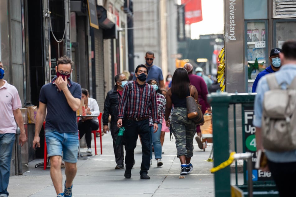 New York: Fußgänger gehen mit Mund-Nasen-Bedeckungen am Broadway . Seit Beginn der Pandemie sind in den USA mehr als sieben Millionen Covid-19-Infektionen verzeichnet worden.