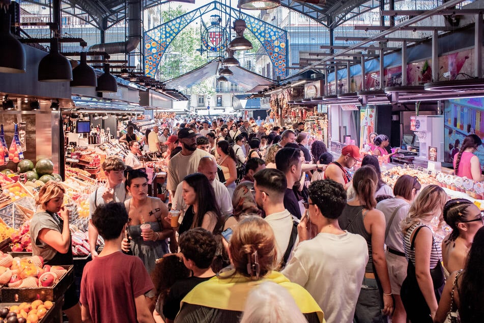 Volle Gänge, lautes Stadtleben: Einheimische ärgern sich über die Touri-Ströme, wie hier auf dem Markt "La Boqueria". (Archivbild)