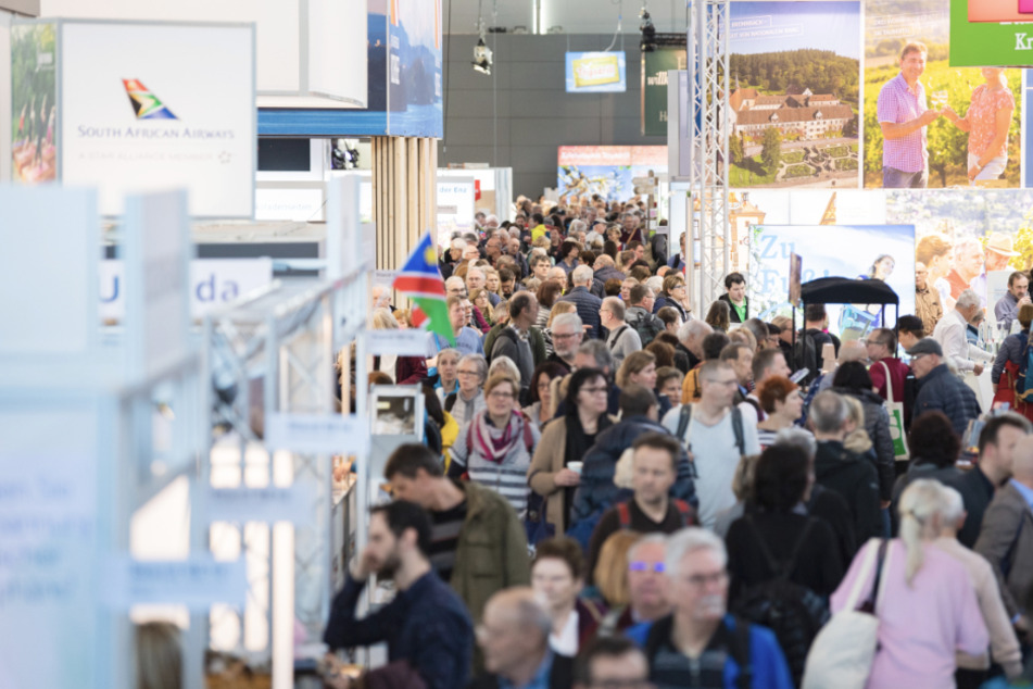 Besucher gehen bei der Reisemesse CMT durch eine Halle der Messe Stuttgart.