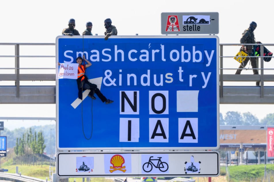 Ein Aktivist hängt bei einer Banneraktion an einer Schilderbrücke über der Autobahn A9 bei Fürholzen in Fahrtrichtung München.